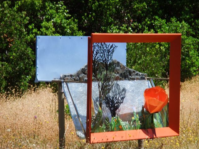 Artist Alicia Lee Farnsworth created this 4 by 6 by 2.5 foot perforated steel  repouse landscape of Clear Lake and mosaic Mt Konoct. It is freestanding in a grassy natural park in Middletown California and has a big international orange wooden picture frame. Part of the 2010 Lake County Ecoarts 10 Sculpturewalk.